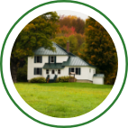 A large white country home with a green roof. 